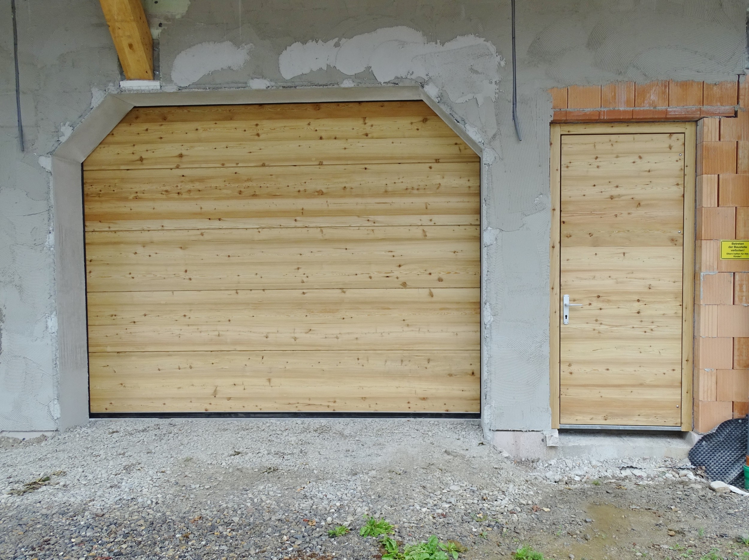 Holz-Sektionaltor und Nebeneingangstür in Lärche "rustikal"