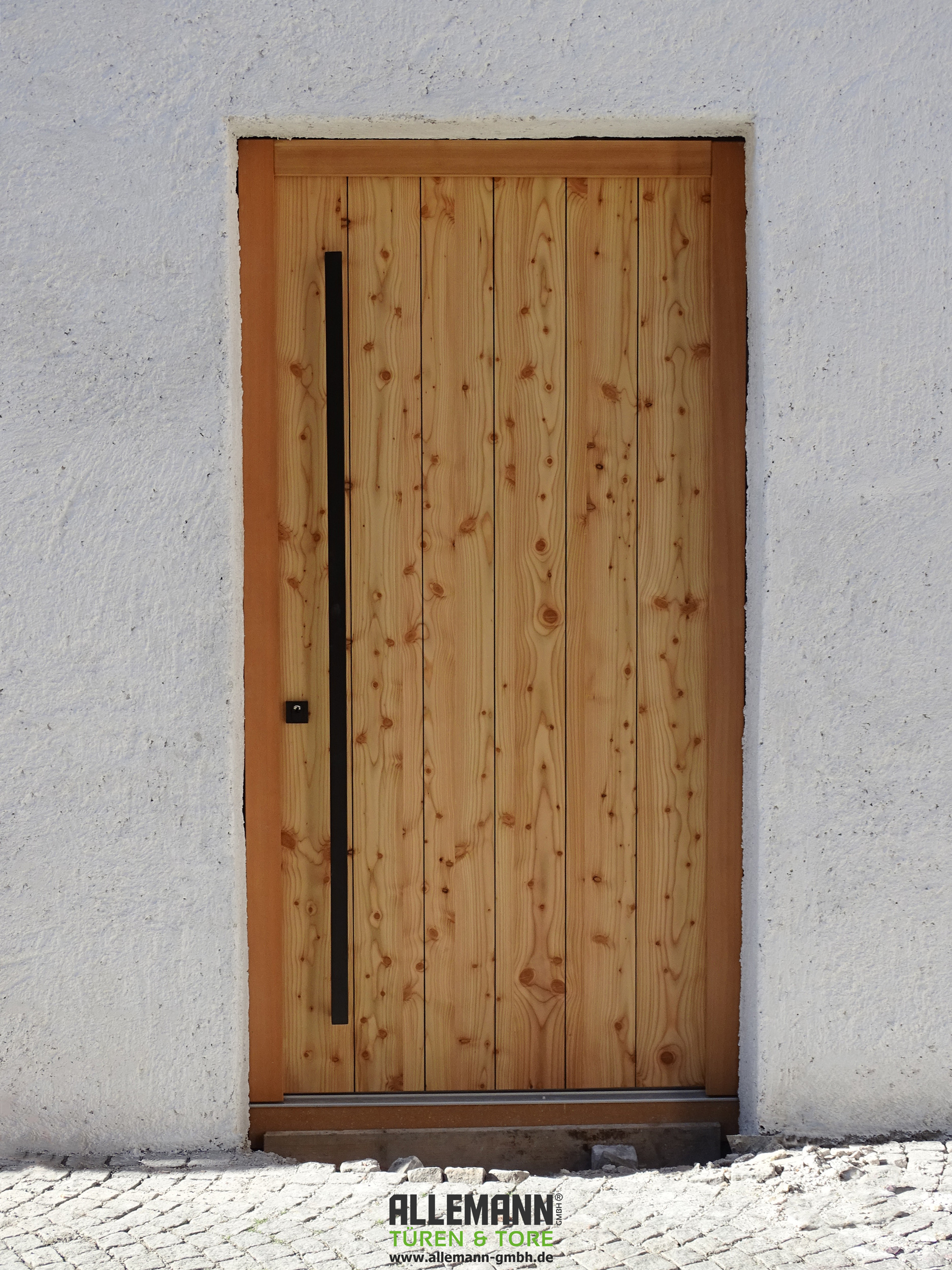 Holz-Haustür-Lärche-senkrecht-mit-Designfräsungen-in-V-Form-schwarz,-farblos-geölt,-Stoßgriff-Korsika-und-Schutzrosette-eckig,-schwarz-matt,-1180-x-2270.jpg