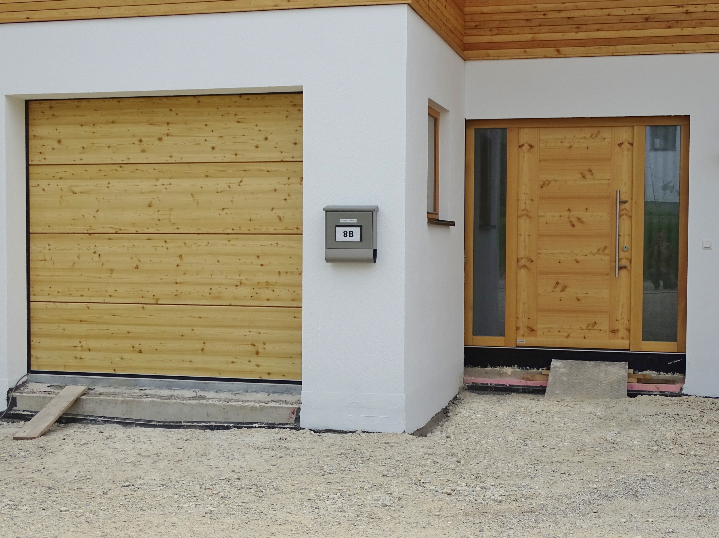 Haustür mit Seitenteilen und Holz-Sektionaltor in Lärche