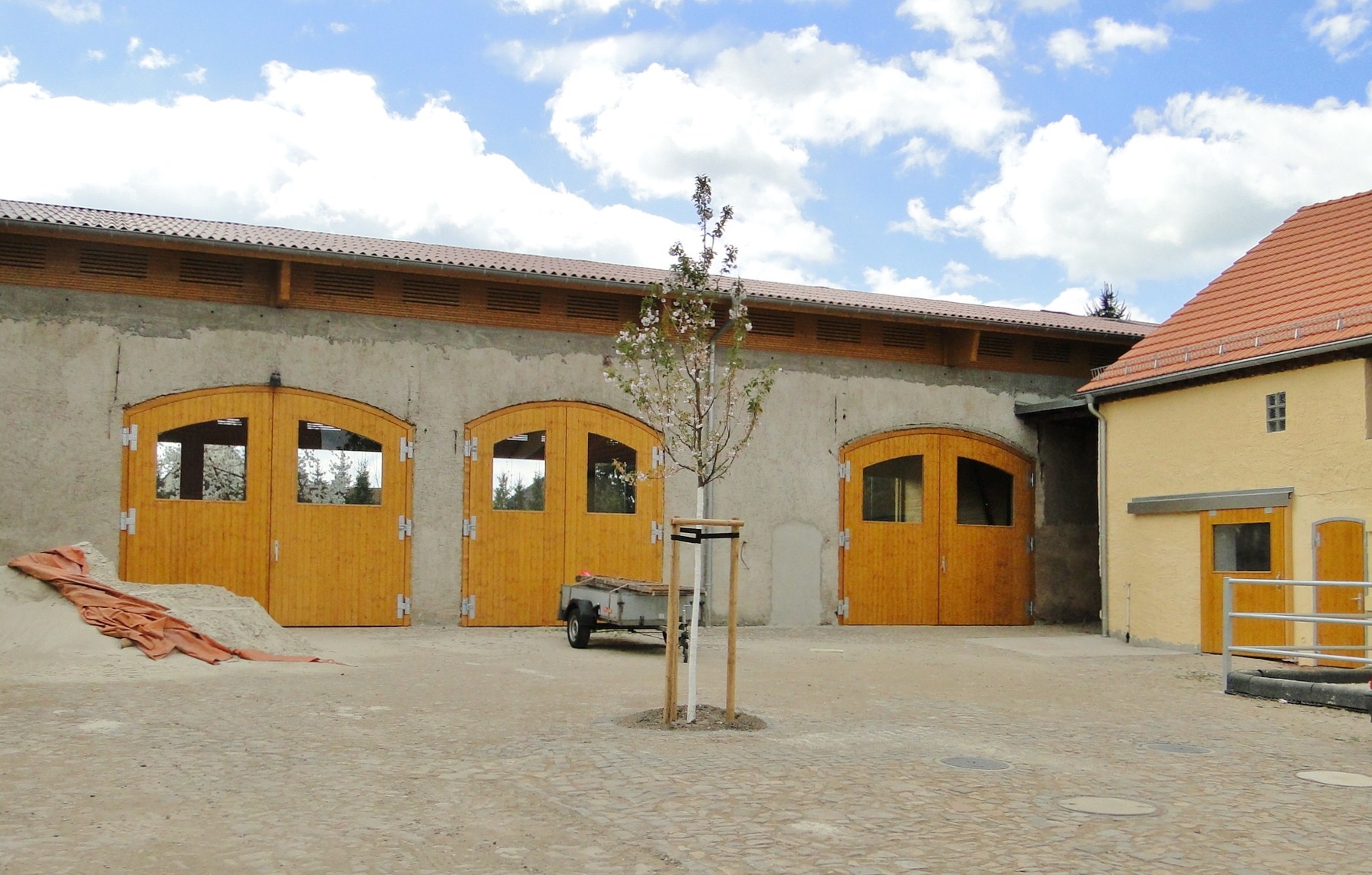 Bogentore mit Holzblockzarge in Reitanlage, rechts Schiebetür und Flügeltür.JPG