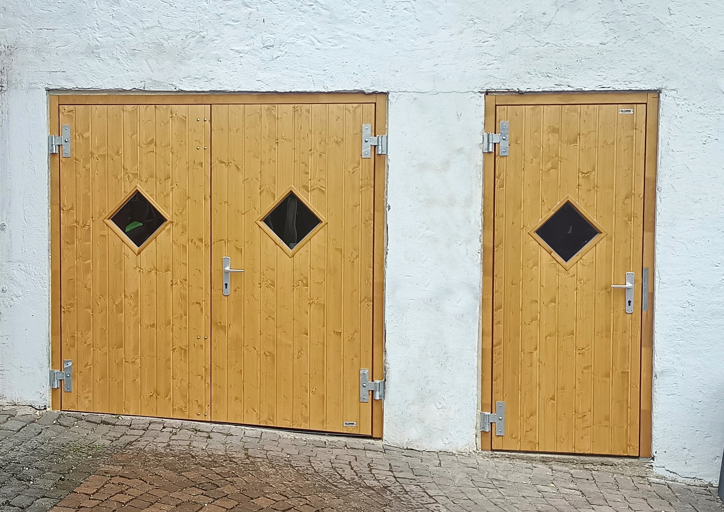 Tür und Tor in Fichte, Endanstrich Eiche-hell, Holzblockzarge und Karofenster